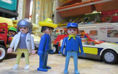 trois playmobil devant des vehicules